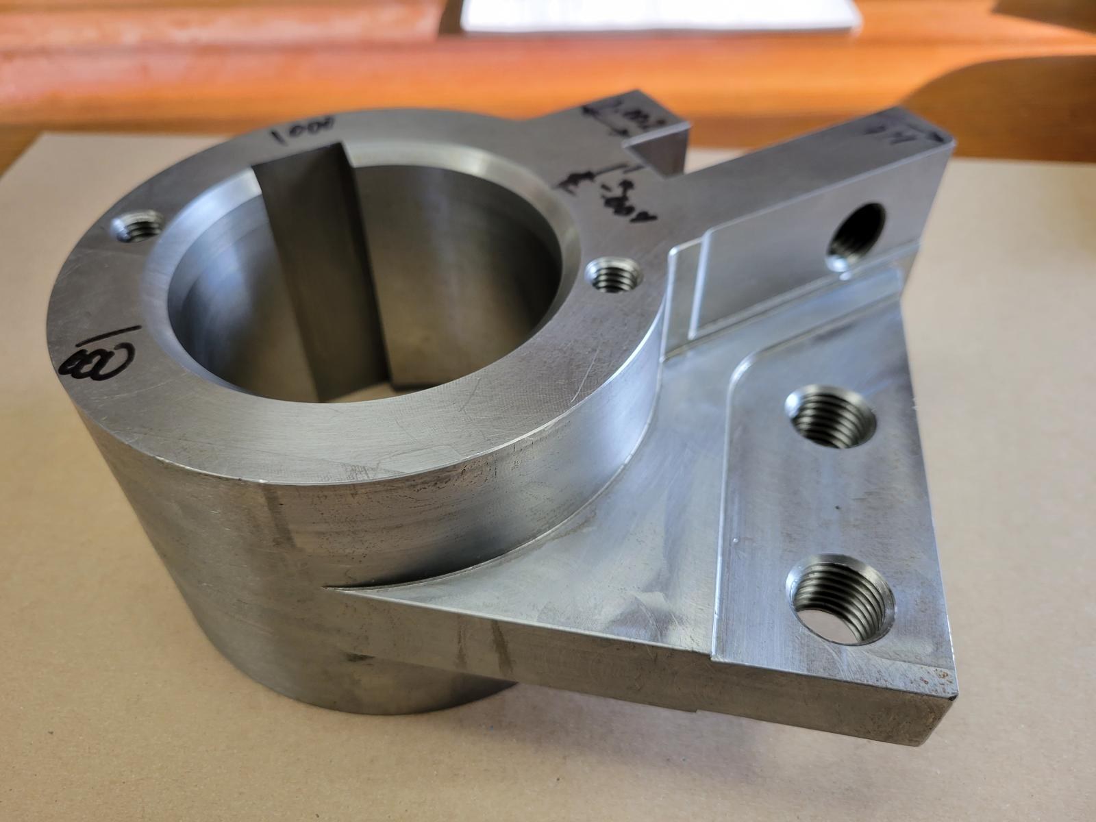 Machined bracket with bored and threaded features